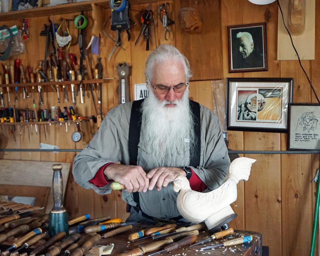Woodworker Phil Odden carving in his home studio.