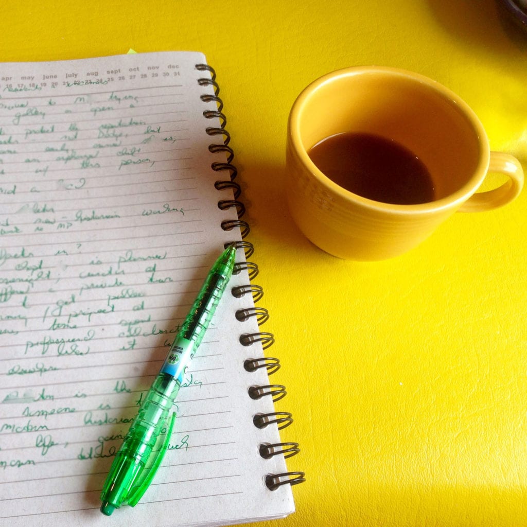 A tabletop with a cup of coffee and a page from the notebook of writer Kathleen Ernst