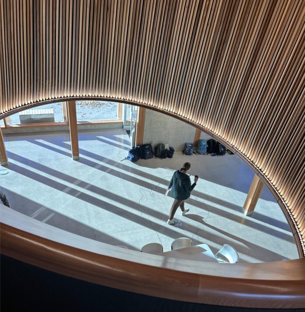 View through the oculus shows a Luther student walking through the lobby of Vesterheim Commons.